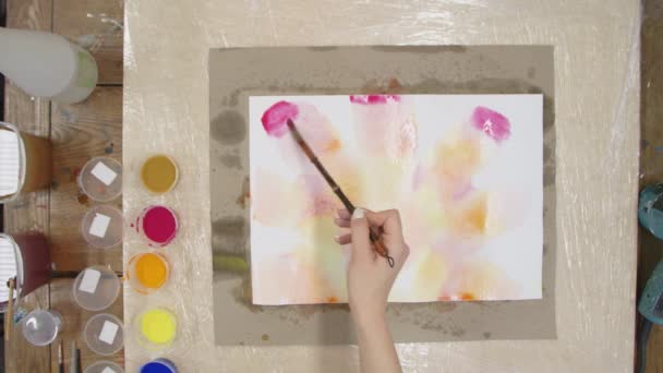 Ovanifrån av kvinnliga konstnären målar pastell slips färgämne bild med gul, röd och orange färger på våt duk. Vätskekonst. — Stockvideo