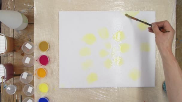 Vista superior de pinturas de artista masculino Tinte de corbata Pastel o imagen de remolino Pastel con pintura amarilla sobre lienzo húmedo. Arte fluido. — Vídeo de stock