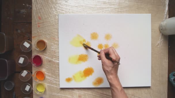 В верхней части картины художник рисует пастельные галстуки или пастельные закручивания с желтыми и оранжевыми красками на мокром холсте. Fluid Art. — стоковое видео