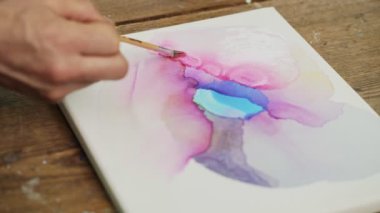 Sıvı Sanat. Soyut renkli tablolar. Dişi ressamlar tuvale su döker ve boya fırçasıyla dağıtırlar.