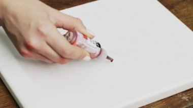 Ressamların yakın çekimleri soyut bir resim, ıslak tuvale bir damla kırmızı boya döküyor ve resim yapmak için boya fırçası kullanıyor.