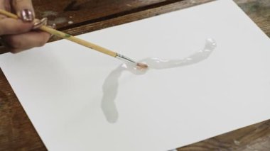 Sıvı Sanat. Soyut renkli tablolar. Kadın ressamın kopyaları tuvale boya fırçasıyla su dağıtır.