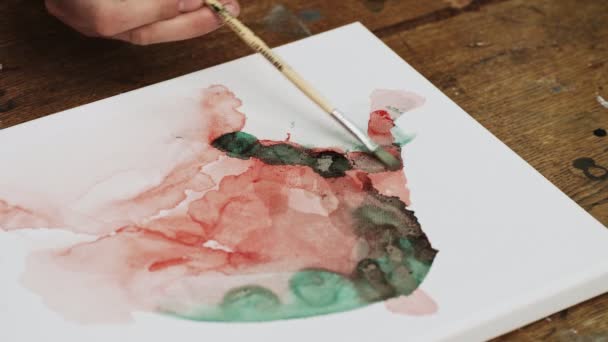 Vista superior do artista pinta uma imagem abstrata, ele usa pincel em tela molhada — Vídeo de Stock