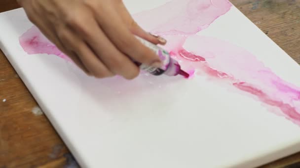 Primer plano de la artista femenina pinta un cuadro abstracto, utiliza el tubo de fron de pintura rosa en las lonas húmedas — Vídeos de Stock