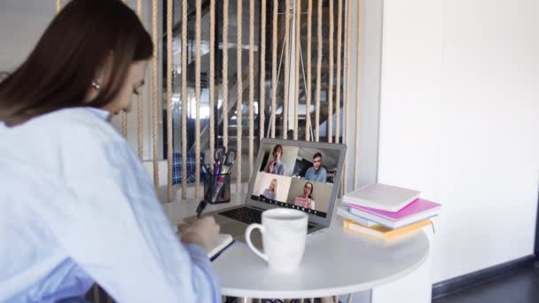 Over shoulder closeup view of remote employee conferencing in online group virtual chat on laptop screen. Company staff colleagues and boss using pc video call app working from home office by web cam. — Stock Video