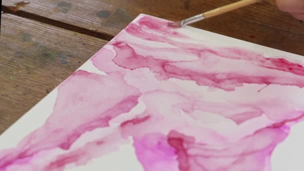 Kadın ressamın yakın çekimi soyut bir resim çiziyor, boya fırçasıyla ıslak tuvale pembe boya dağıtıyor. — Stok video