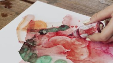 Sıvı Sanat. Soyut renkli tablolar. Sanatçı soyut resim çizmek için kırmızı boya ve fırça kullanır