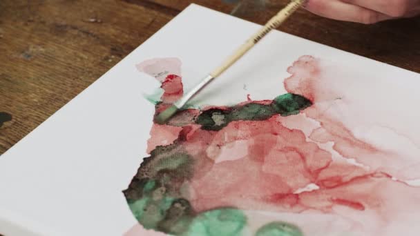 Vista superior do artista pinta uma imagem abstrata, ele usa pincel em tela molhada — Vídeo de Stock