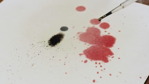 Közelkép művész fest egy absztrakt képet, ő öntött néhány csepp fekete festék vászon és a víz spray mozgatni, hogy a festék — Stock videók
