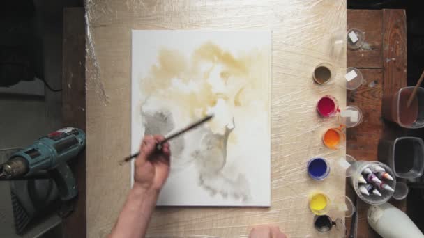 Folyékony művészet. Absztrakt színes festmény. Top view férfi művész használ ecsetet festeni gyönyörű fekete absztrakt formák nedves vászonra — Stock videók