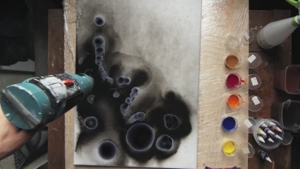 Sıvı Sanat. Soyut karanlık resim. Erkek ressamın üst görüntüsü ıslak tuval üzerinde kuru boya ve hareket etmek için kurutucu kullanır. — Stok video