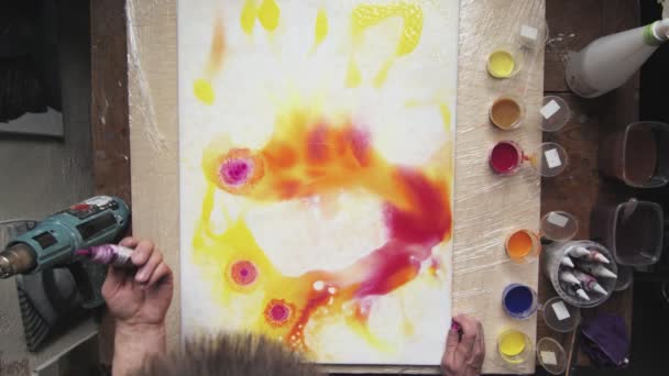 Vista superior do artista masculino pinta uma imagem abstrata, ele derrama um monte de algumas gotas de tinta vermelha para tela molhada — Vídeo de Stock