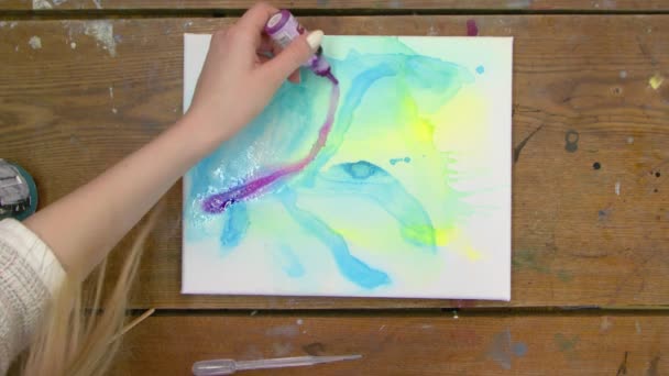 Sıvı Sanat. Soyut mavi ve sarı resim. Ressamın üst görüntüsü soyut ıslak bir resme mor boya ekler — Stok video
