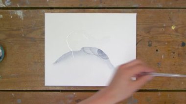 Sıvı Sanat. Soyut renkli tablolar. Kadın ressamın üst görüntüsü pipetten tuvale su döker