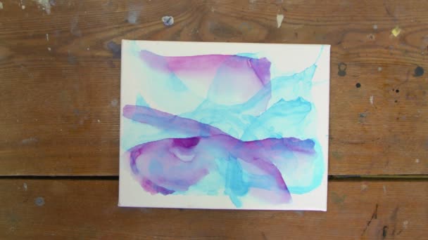 Arte Fluida. Pintura azul abstrata. Vista superior da artista feminina usa secador para secar sua nova imagem de Arte Fluida com cores azul e roxo — Vídeo de Stock
