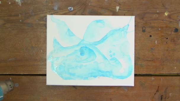 Arte Fluida. Pintura azul abstrata. Vista superior do artista feminino usa secador para fazer imagem abstrata azul — Vídeo de Stock