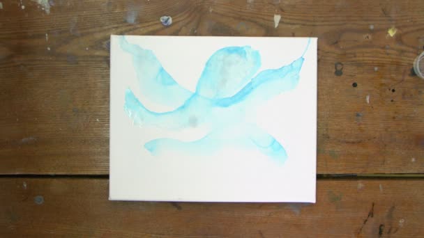 Tampilan atas pelukis gambar abstrak, dia menggunakan kuas cat dengan cat biru dan pengering — Stok Video