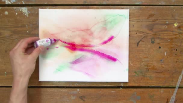 Vedere de sus a artistului pictează o imagine abstractă, el pictează forme abstracte cu vopsea violet pe pânză umedă — Videoclip de stoc