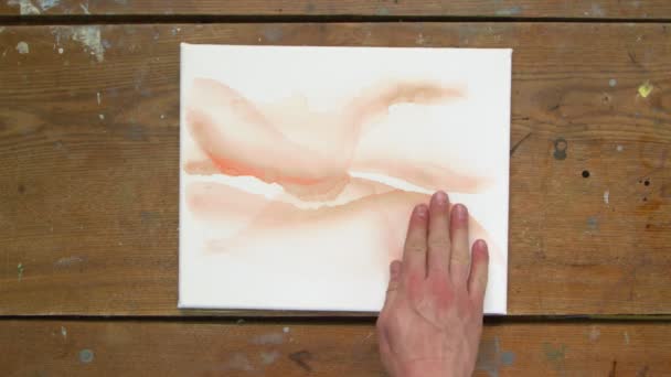 Arte Fluida. Pintura colorida abstrata. Vista superior do artista masculino usa secador para secar tela e verifica com a mão — Vídeo de Stock