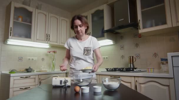 Hausfrau legt mit Silikonspachtel Butter in Schüssel mit Zucker — Stockvideo