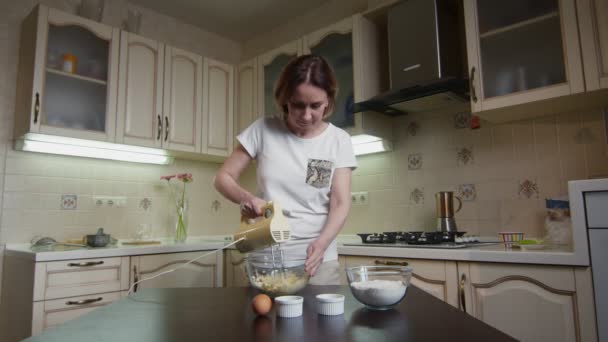 Hausfrau mixt Zutaten für Kuchen in der Küche — Stockvideo