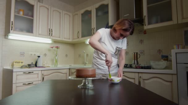 Hausfrau bereitet Schokoglasur zum Dekorieren von Kuchen zu — Stockvideo