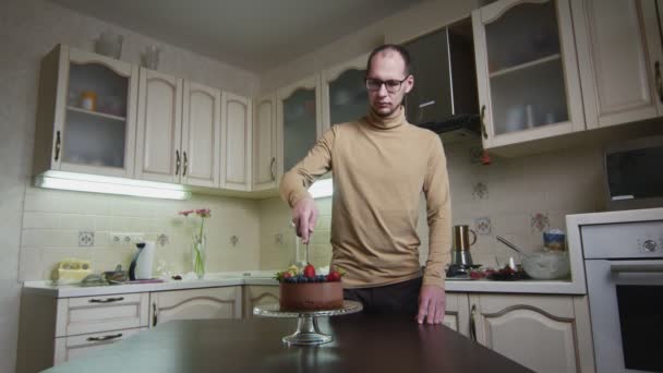 Männlicher Koch schneidet seinen neuen Schokoladenkuchen in der Küche — Stockvideo