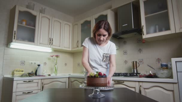 Hausfrau schneidet ihrem Neuen den Schokoladenkuchen auf und legt einen Frieden auf den Teller — Stockvideo