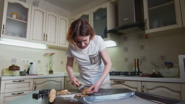 Домогосподарка кладе вирізане імбирне печиво на лист для випічки — стокове відео