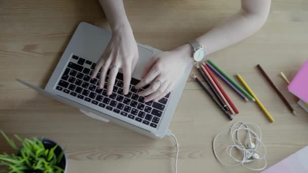 Egy fiatal nő laptopon gépel. Fa asztalra helyezve — Stock videók