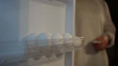 POV, bir buzdolabının içinde kapıyı açan ve yiyecekleri alan bir kadının fotoğrafını çekti.