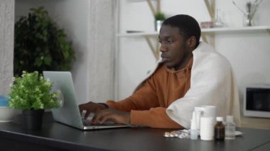 Hasta, Afro-Amerikalı bir adam öksürüyor ve evde dizüstü bilgisayar kullanıyor..