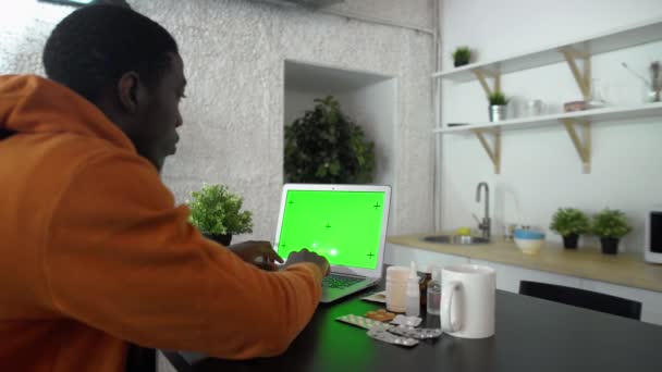 Widok wsteczny chorych młodych Afrykańczyków typu mężczyzna na notatniku z zielonym ekranem — Wideo stockowe