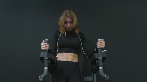 Ομορφη γυμναστικη γυναικα σε κιτρινο τοπ Ασκηση Στο γυμναστηριο, κανει κρεμασμενο γονατο Raise Exercise — Αρχείο Βίντεο