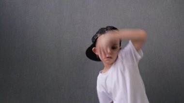 Beyaz çocuk dans ederek zıplıyor. Yeteneğin ve hobinin ifadesi. Mutlu bir çocukluk. Rhythm 'de müzik dinleyip dans eden ergen çocuk.