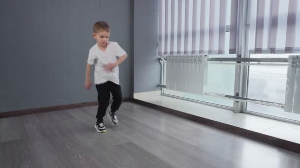 Μικρή αρσενική χορεύτρια που εκτελεί επαγγελματικά δημοφιλή στοιχεία του αστικού χορού — Αρχείο Βίντεο