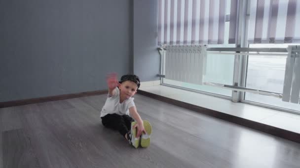 Μικρό αγόρι κάνει άσκηση για να τεντώσει και κάνει τα split μετά breakdance hip-hop μάθημα χορού — Αρχείο Βίντεο