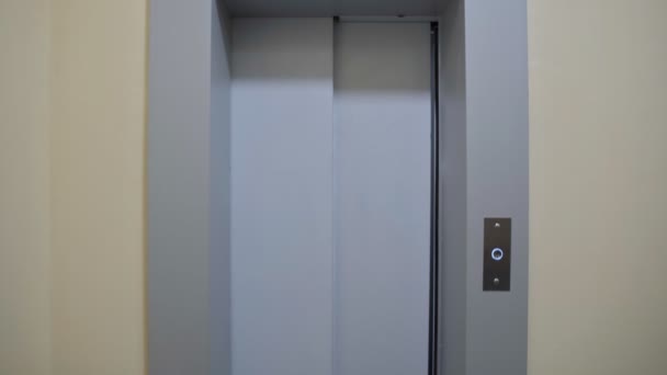 Νεαρό ζευγάρι των δύο ανδρών κατέχει κουτιά από χαρτόνι και τη δημιουργία έξω από το ασανσέρ, κινείται σε νέο διαμέρισμα — Αρχείο Βίντεο