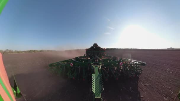 Close up of tractor with harrow system plowing ground on cultivated farm field, pillar of dust trails behind, preparing soil for planting new crop — Stock Video