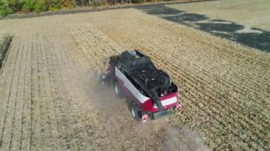 Hasat biçme makinesi mekanizması buğday dikenlerini keser. Tarım ürünleri hasat işi. Hasat makinesi tarlada hareket eder ve olgun buğday biçer. Büyük hasatçı gün batımında tahıl toplar. tarımsal iş