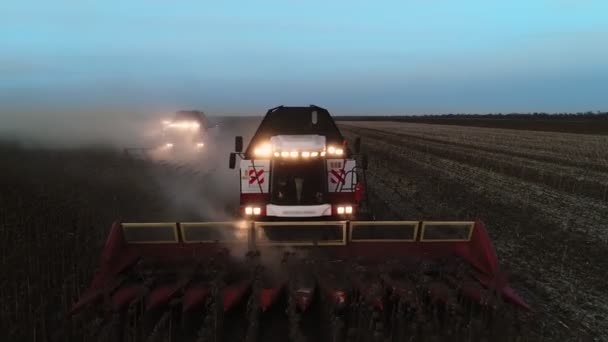 Colheitadeira máquina para colher campo de girassol trabalhando à noite. Combine colheitadeira agricultura máquina de colheita campo de girassol. Um campo depois de uma colheita. — Vídeo de Stock