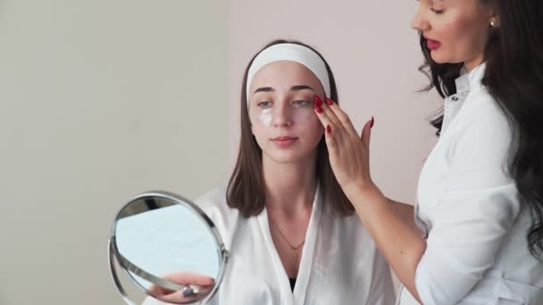 Giovane donna con rilievi di collagene sotto gli occhi si guarda allo specchio — Video Stock