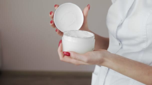 Close-up van professionele schoonheidsspecialiste opent een witte fles met lotion — Stockvideo