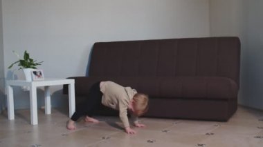 Sevimli çocuk dans ediyor ve zıplıyor evde eğleniyor.