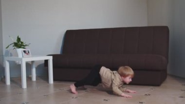 Sevimli çocuk dans ediyor ve zıplıyor evde eğleniyor.