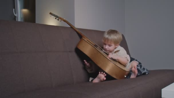 Küçük çocuk gitar çalar ve şarkı söyler.. — Stok video