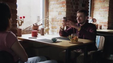 Adam kız arkadaşının fotoğrafını çekiyor. Çin Çay Kafesi 'nde birlikte rahatlayan çiftler.