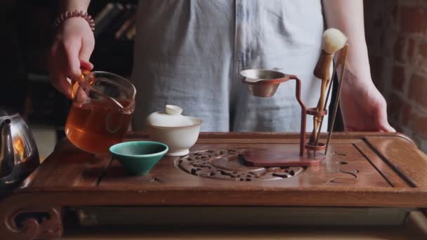 Традиционная китайская чайная церемония. Горячий чай из чайника течет в аккуратном ручье в Гайване — стоковое видео