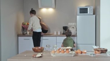 Üç kardeş mutfakta kahvaltıda krep pişirdikten sonra el yıkıyorlar..