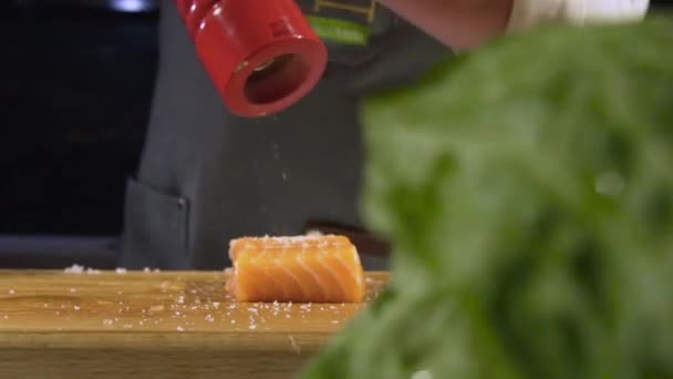 Dekat dengan chef salting salmon di meja kayu — Stok Video